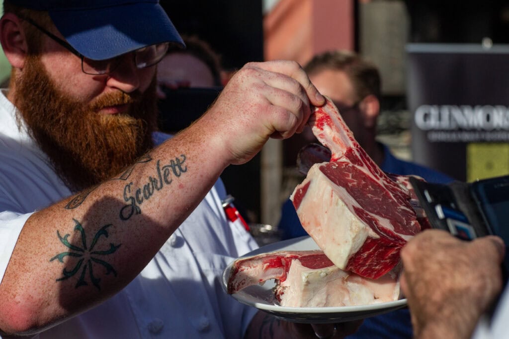 Chef holding beef at Chefs on Fire event photo by Epicure The Event